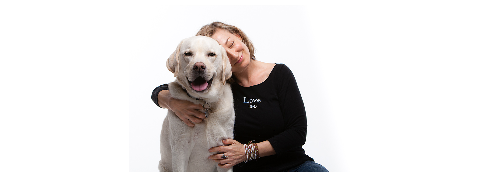 Positivity Designs Founder wearing Love T-shirt and hugging dog